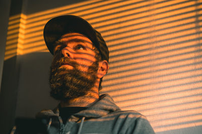 Close-up of man standing against curtain