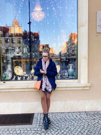 Full length of young woman standing in city