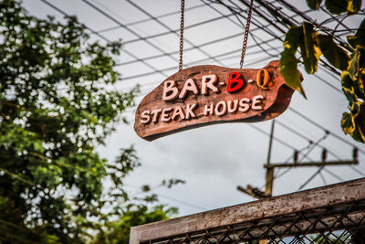 Low angle view of information sign against trees