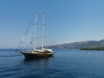 Sailboat sailing on sea against clear sky