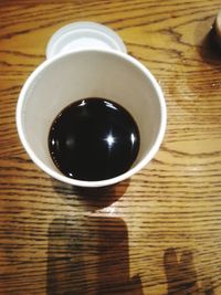 High angle view of coffee cup on wooden table