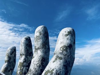 Low angle view of rocks against blue sky