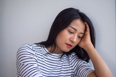 Portrait of beautiful woman with eyes closed against wall