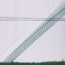 Abstract image of staircase on white building by grassy field