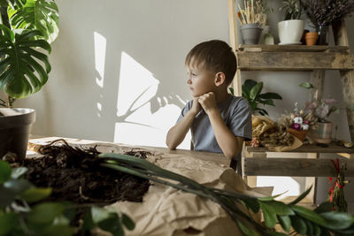 Boy sitting at table in living room
