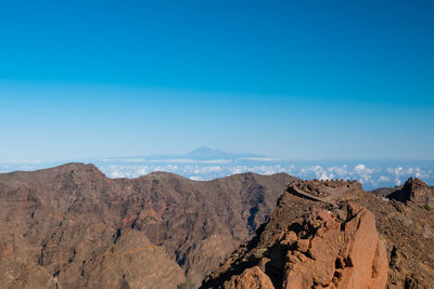 Scenic view of mountains against blue sky