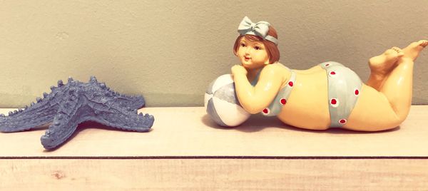 Portrait of young woman with toy sitting on table