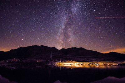 Scenic view of lake against sky at night