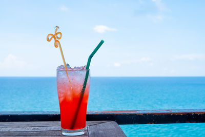 View of wine glass in swimming pool against sea