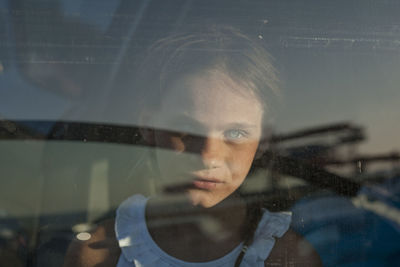 Portrait of girl seen through glass window