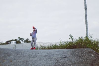 Low angle view of woman standing against sky