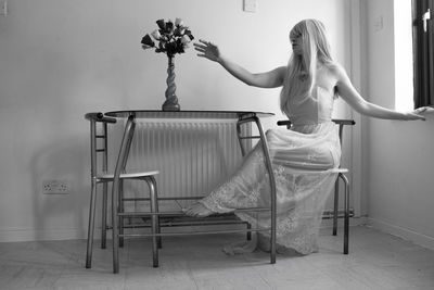 Young woman with flowers on chair