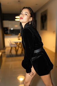 Portrait of young woman standing in the living room 