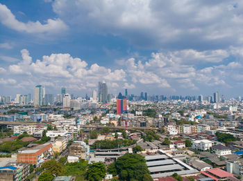 Aerial view of buildings in city against sky