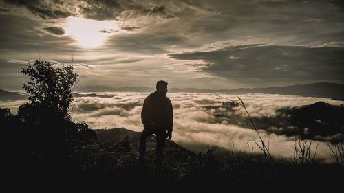 Rear view of silhouette man standing on field against sky