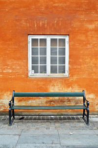 Empty bench against building