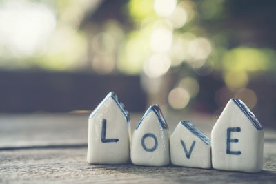 Close-up of love text on model homes at table