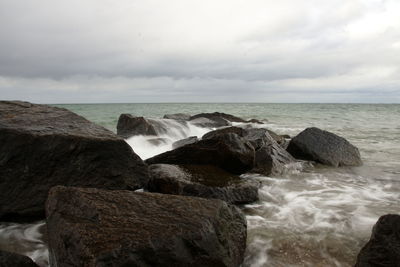 Scenic view of rocks in sea against sky