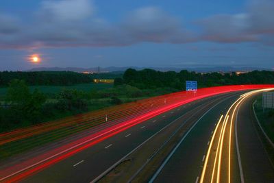 Light trails on country road at dusk