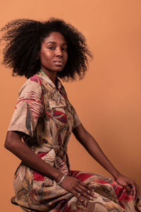 Portrait of woman standing against gray background