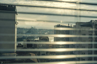 Buildings seen through wet glass window in rainy season