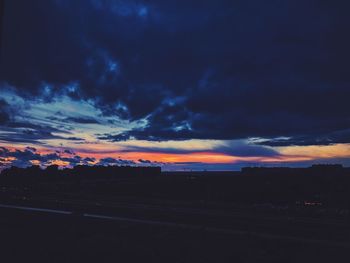 Silhouette landscape against dramatic sky during sunset