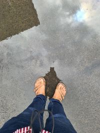 Low section of man standing by water