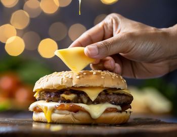 Close up of a hand picking up a single slice of buger