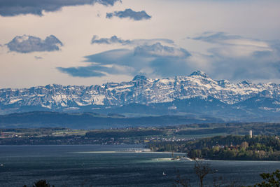 Scenic view of snowcapped mountains by sea against sky