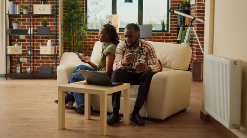 Side view of woman using digital tablet at home