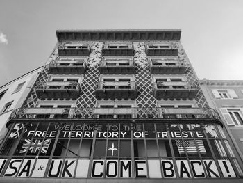 Low angle view of text on building against sky