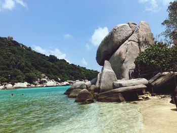 Rock formation by sea against sky