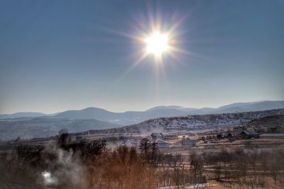 Scenic view of landscape against bright sun