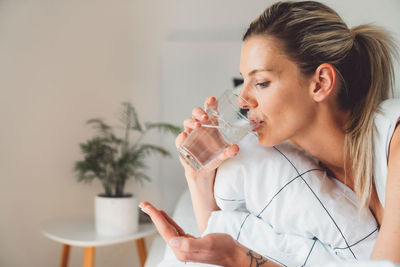 Young woman blowing bubbles while sitting at home