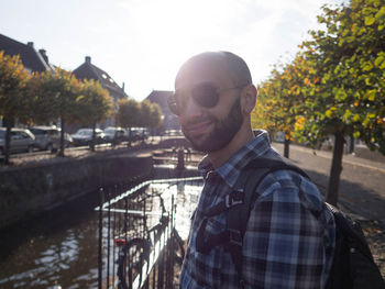 Portrait of young man standing against built structure