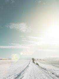 Scenic view of snow covered field against sky