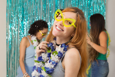 Portrait of smiling young woman standing by friends during party