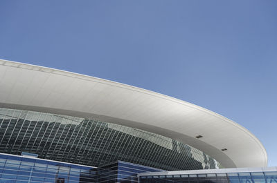 Low angle view of modern building against blue sky
