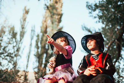 Boy with sister wearing costume during halloween at forest
