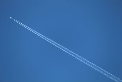 Low angle view of vapor trail against blue sky