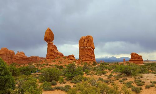 Rock formations on landscape against cloudy sky