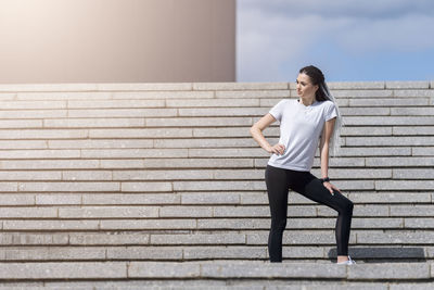 Full length of woman standing against wall