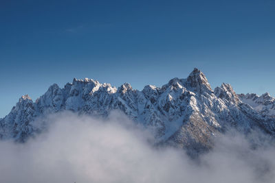 Scenic view of snowcapped mountains against clear blue sky