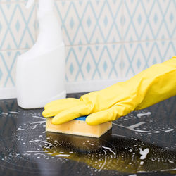 Yellow sponge on the stove in the foam. general cleaning concept.