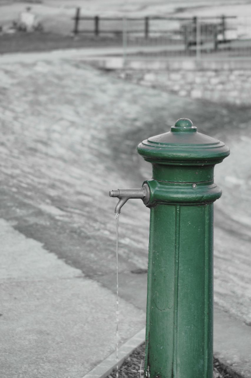 focus on foreground, outdoors, day, green color, close-up, no people, water, fire hydrant, cleat, nature