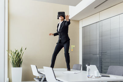 Full length of man standing on table against wall