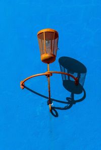 Low angle view of illuminated lamp post against blue sky