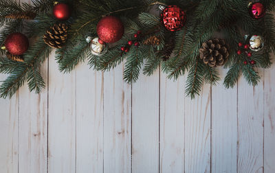 Christmas greenery and decorations against rustic white wood backdrop.