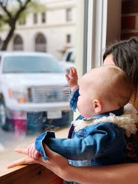 Girl and sister looking through window