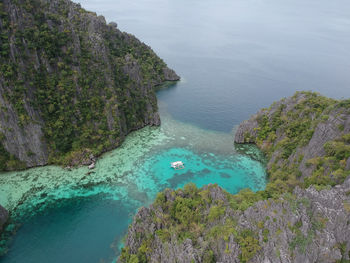 High angle view of sea by mountains against sky